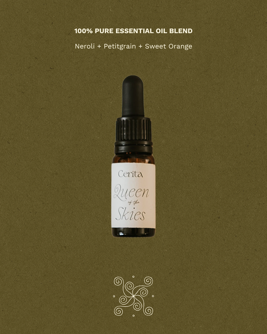 bottle of queen of the skies essential oil blend by Cerita on green background with fragrance notes text