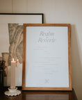 Load image into Gallery viewer, minimal typography a3 paper art print realm of reverie by Cerita in wooden frame on dresser with candle in neutral interior setting
