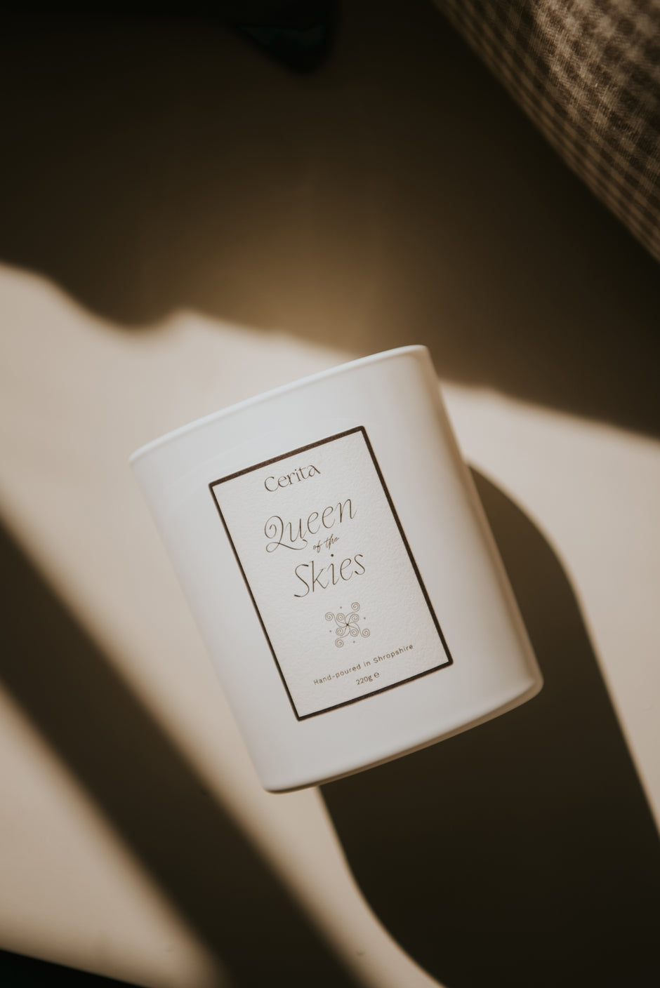 queen of the skies candle by Cerita on neutral surface with light and shadow