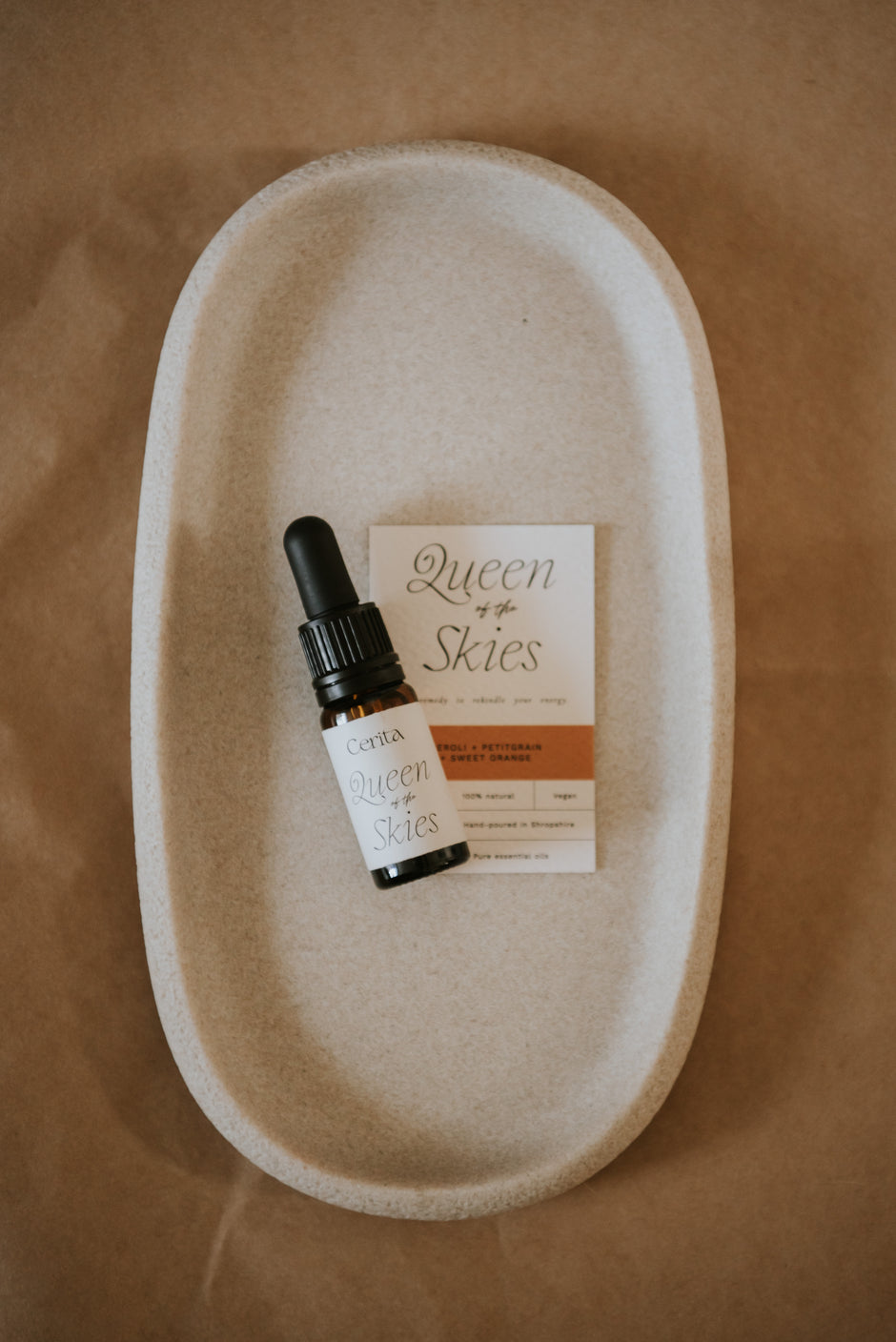 bottle of queen of the skies essential oil blend by Cerita on neutral ceramic dish